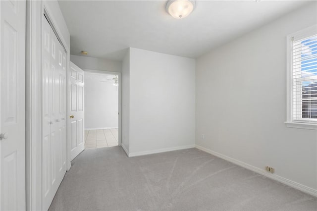 empty room with baseboards and light colored carpet