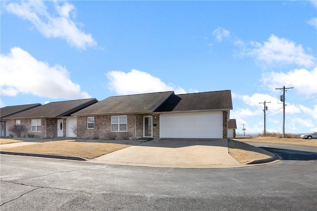 ranch-style house featuring concrete driveway, brick siding, and an attached garage