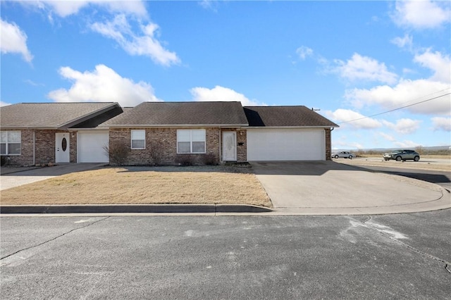 view of front facade featuring concrete driveway, brick siding, and an attached garage