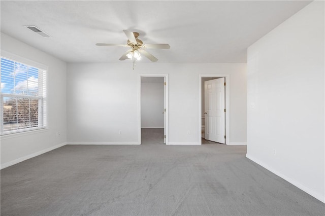 spare room featuring a ceiling fan, light colored carpet, visible vents, and baseboards