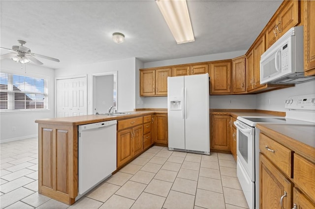 kitchen featuring white appliances, ceiling fan, brown cabinets, a peninsula, and light countertops