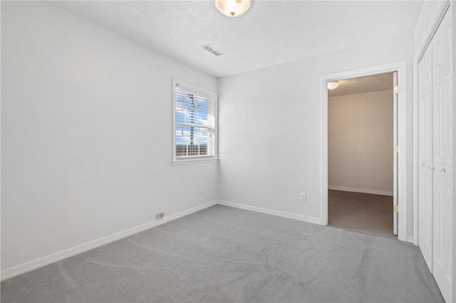 unfurnished room with baseboards, visible vents, and light colored carpet