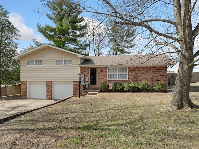 tri-level home with a garage, brick siding, fence, and driveway