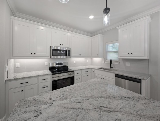 kitchen featuring a sink, white cabinets, hanging light fixtures, appliances with stainless steel finishes, and tasteful backsplash