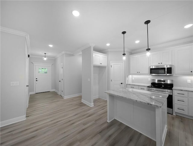 kitchen with a kitchen island, light stone counters, hanging light fixtures, stainless steel appliances, and white cabinetry