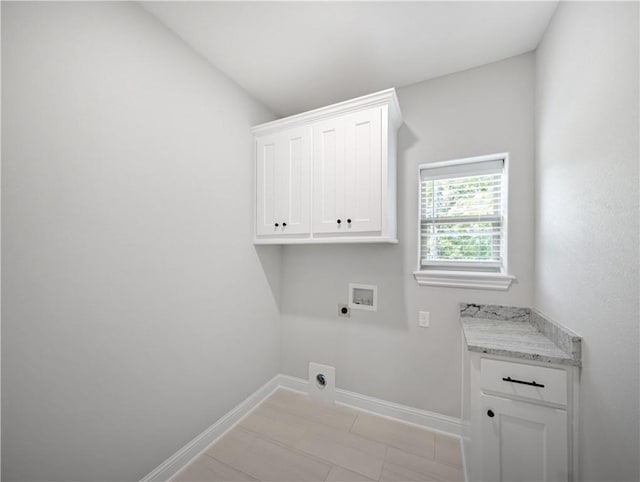 washroom with hookup for a washing machine, hookup for an electric dryer, cabinet space, and baseboards