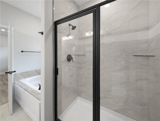 bathroom featuring a stall shower and a bath