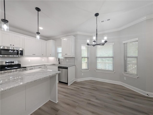 kitchen featuring visible vents, decorative light fixtures, light stone countertops, stainless steel appliances, and white cabinetry