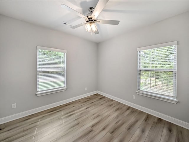 empty room featuring visible vents, ceiling fan, light wood-style flooring, and baseboards