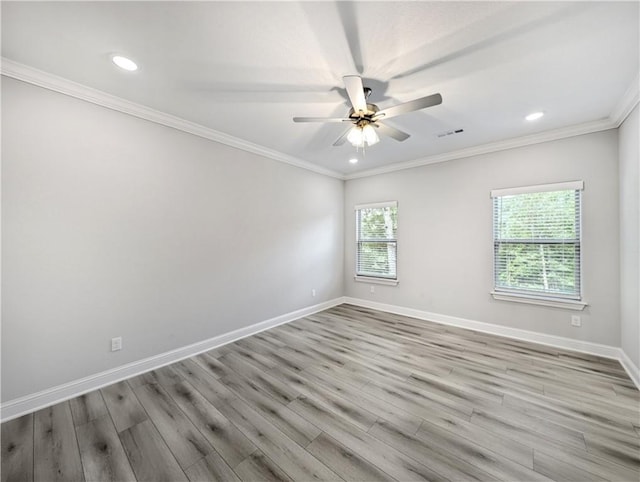 empty room featuring light wood finished floors, visible vents, baseboards, ceiling fan, and crown molding