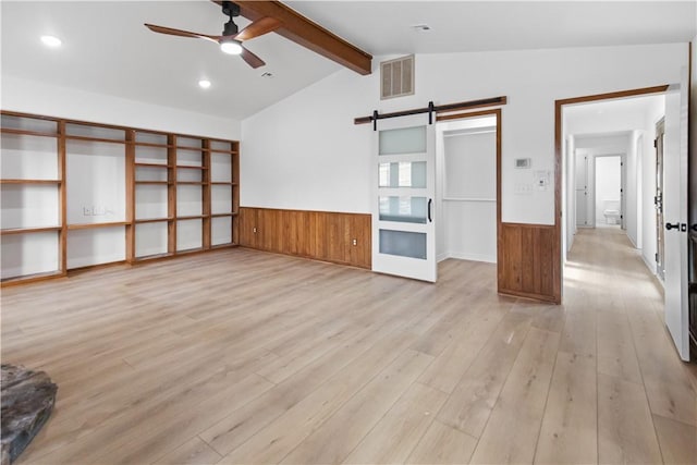 916 S 25th Pl, Rogers, AR 72758 - unfurnished living room featuring ceiling fan, a wainscoted wall, a barn door, light wood-style floors, and wooden walls