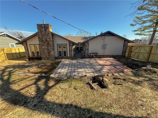 916 S 25th Pl, Rogers, AR 72758 - rear view of property featuring a chimney, a fenced backyard, and stone siding