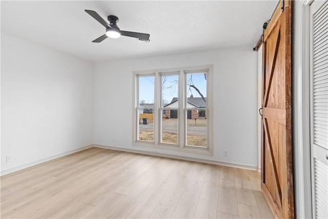 916 S 25th Pl, Rogers, AR 72758 - empty room featuring a barn door, light wood-type flooring, and ceiling fan