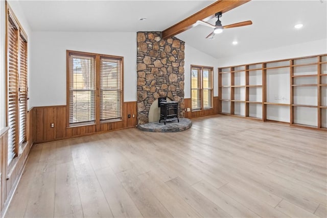 916 S 25th Pl, Rogers, AR 72758 - unfurnished living room with a wood stove, ceiling fan, a wainscoted wall, and wood finished floors