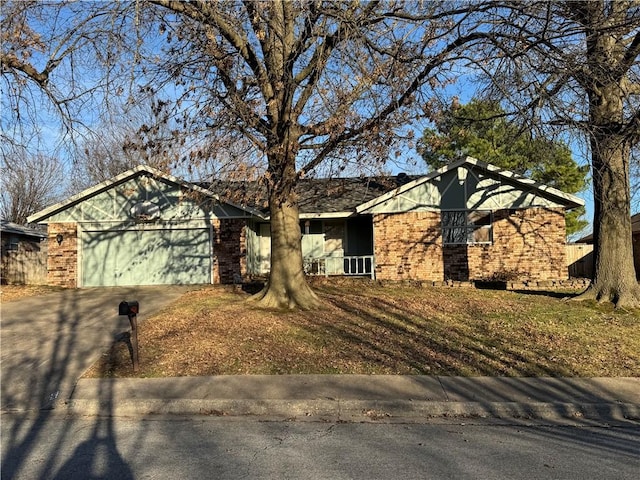 single story home with a garage, concrete driveway, and brick siding