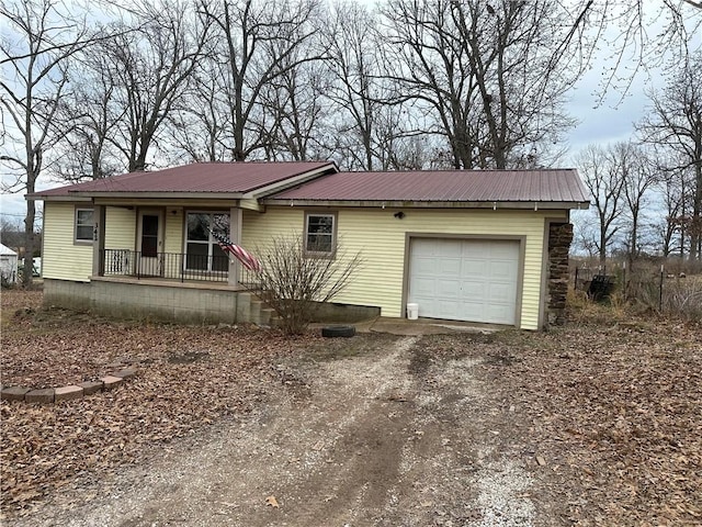 ranch-style house with driveway, metal roof, an attached garage, crawl space, and a porch