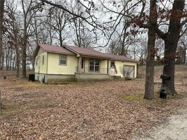 view of front facade with an attached garage, crawl space, and metal roof