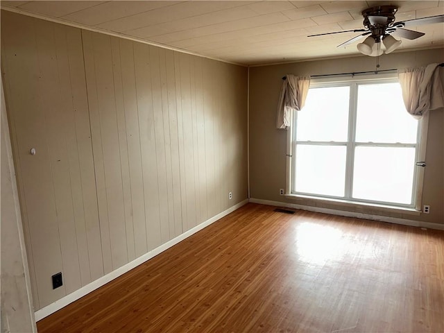 unfurnished room with ceiling fan, baseboards, and wood finished floors