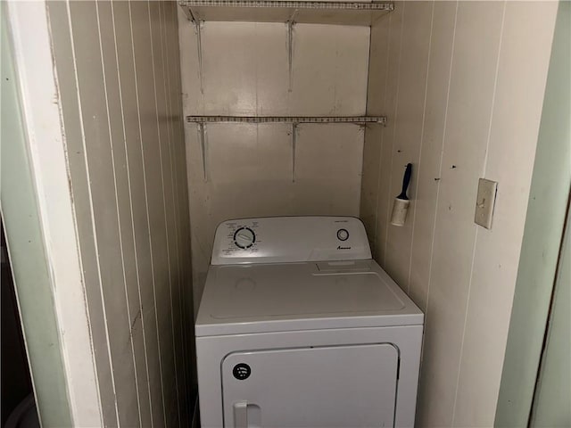 clothes washing area featuring laundry area, washer / dryer, and wooden walls