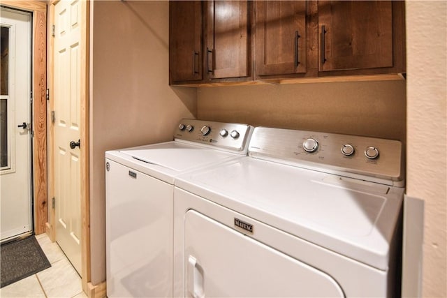 laundry area with light tile patterned flooring, independent washer and dryer, and cabinet space