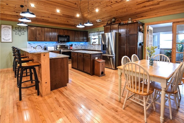 kitchen with a peninsula, wood ceiling, stainless steel appliances, and backsplash