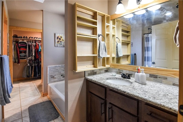 full bath with a garden tub, curtained shower, a spacious closet, vanity, and tile patterned floors