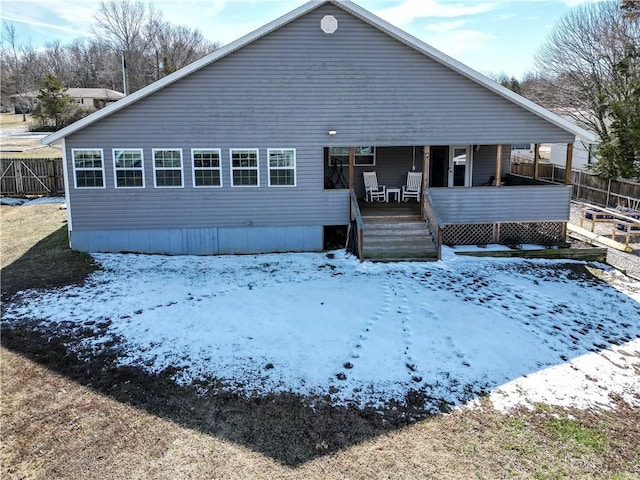 snow covered house with fence