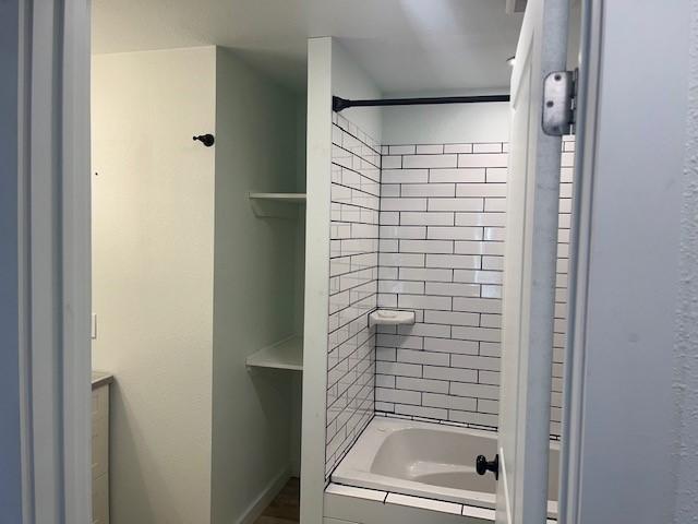 full bath with tiled shower / bath combo and vanity