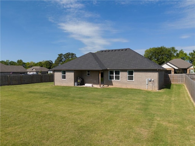 back of house with brick siding, a yard, a shingled roof, a patio area, and a fenced backyard