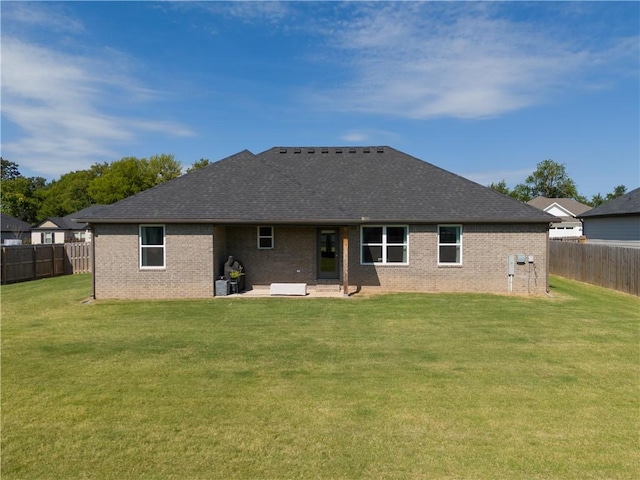 rear view of property with a yard, brick siding, a patio area, and a fenced backyard