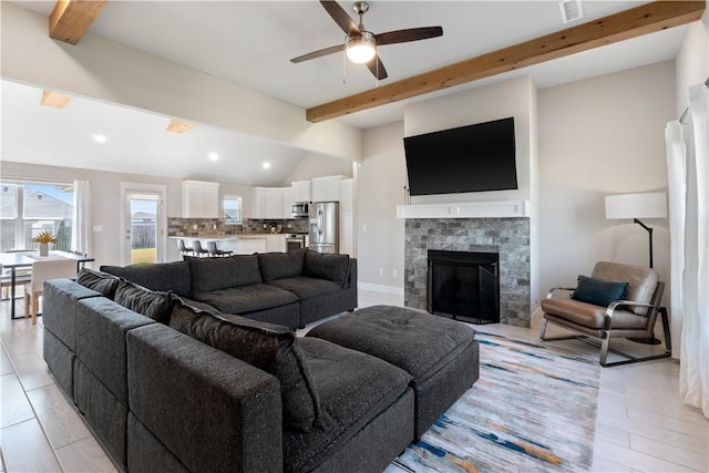 living room featuring baseboards, visible vents, a tiled fireplace, lofted ceiling with beams, and recessed lighting