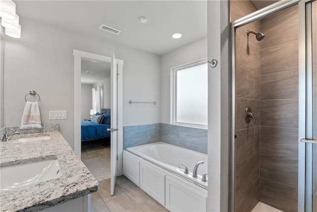 ensuite bathroom with visible vents, a sink, a shower stall, and a bath