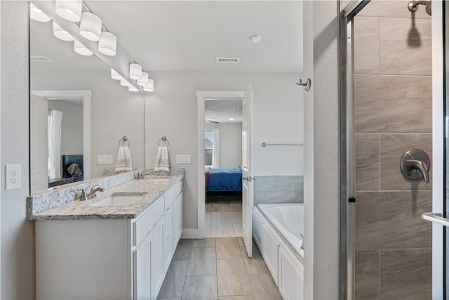 ensuite bathroom featuring visible vents, a sink, a shower stall, and ensuite bathroom