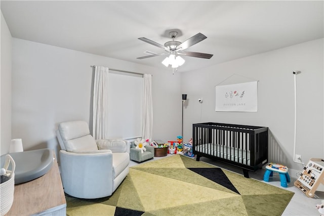 bedroom with a ceiling fan and a crib