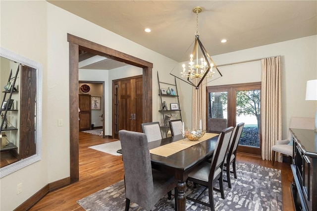 dining space with a chandelier, dark wood-style flooring, recessed lighting, and baseboards