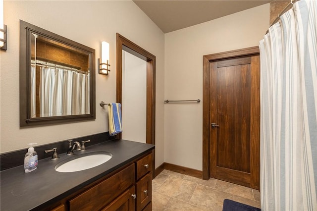 full bath featuring baseboards and vanity