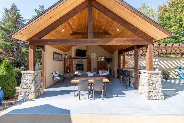 view of patio with a bar and exterior fireplace