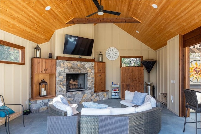 unfurnished living room featuring a stone fireplace, wooden ceiling, a ceiling fan, and a decorative wall