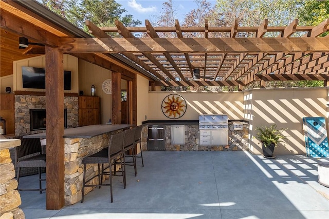 view of patio / terrace featuring grilling area, an outdoor kitchen, outdoor wet bar, and a pergola