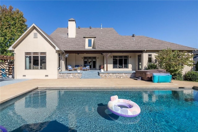 outdoor pool with a patio area and a hot tub