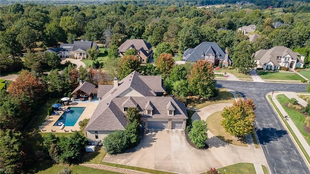 drone / aerial view featuring a residential view and a view of trees