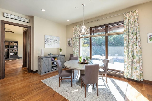 dining area featuring baseboards, wood finished floors, and recessed lighting