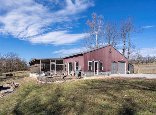 view of outbuilding with an outbuilding, driveway, and a sunroom