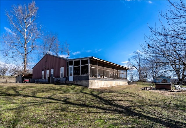 view of side of property featuring a lawn and a sunroom