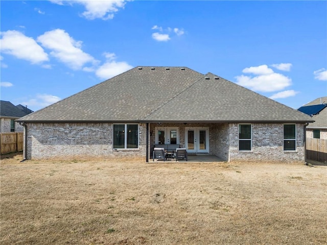 rear view of house featuring french doors, roof with shingles, and fence