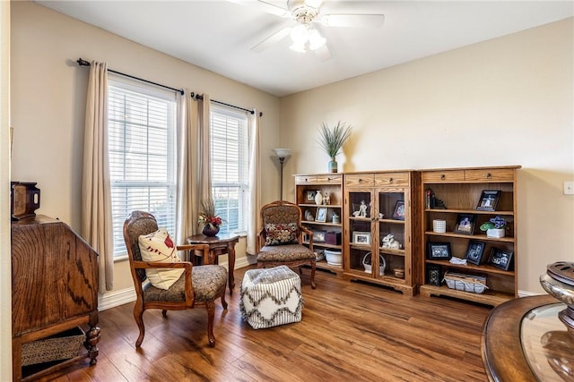 living area featuring ceiling fan, wood finished floors, and baseboards