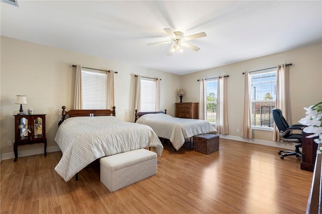 bedroom featuring light wood-style floors, visible vents, ceiling fan, and baseboards