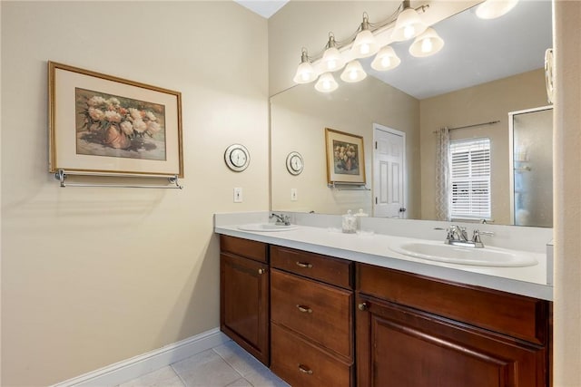 full bathroom featuring double vanity, tile patterned flooring, a sink, and baseboards