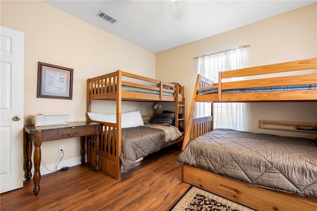 bedroom with wood finished floors, visible vents, and baseboards