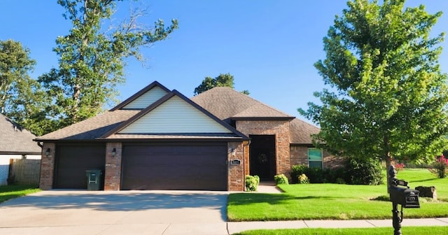 view of front of property with a garage, driveway, a front yard, and brick siding